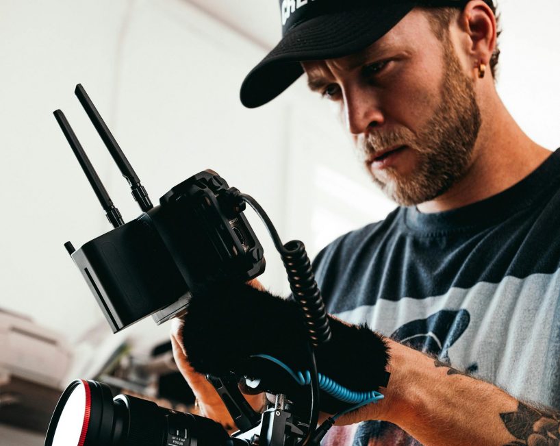 Cinematographer in action adjusting camera equipment on set indoors.